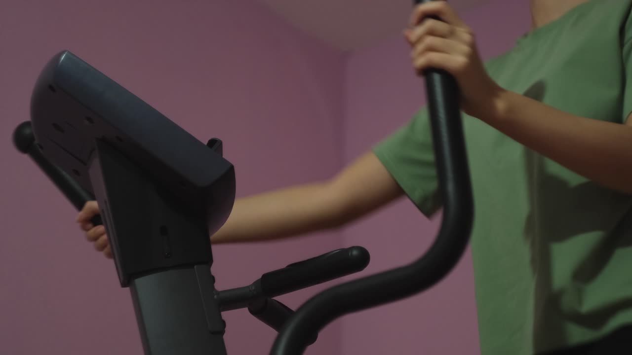 집에서 타원형 트레이너를 사용하는 여성