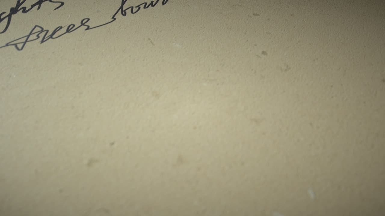 Ink pen writes poetry on old paper on a black background