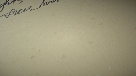 Ink pen writes poetry on old paper on a black background