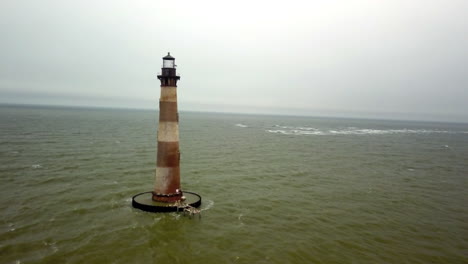 Luftaufnahme-Eines-Nahen-Vorbeiflugs-Am-Leuchtturm-Von-Morris-Island,-Der-An-Der-Südseite-Der-Einfahrt-Zum-Hafen-Von-Charleston-In-South-Carolina-Steht