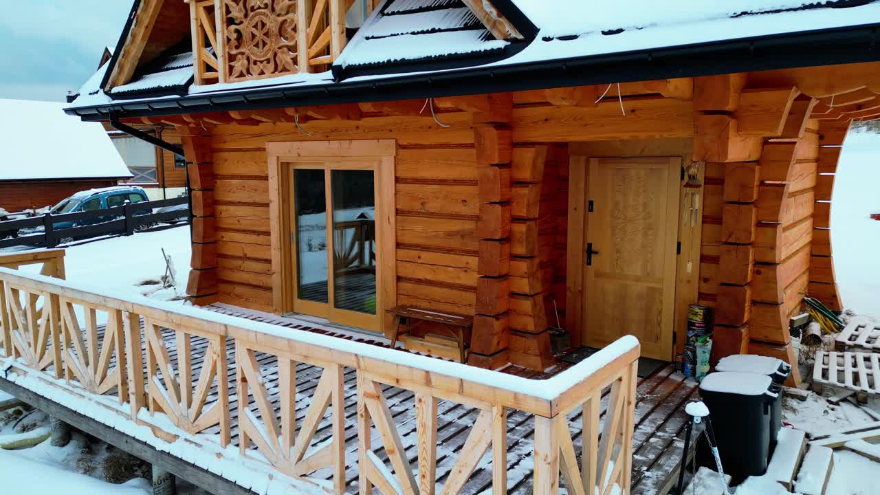 Una baita di montagna artigianale incorniciata da un paesaggio innevato. Atmosfera invernale e suggestiva, tetto innevato e cielo nuvoloso