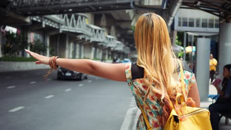 traveler woman show hand call a car on the city