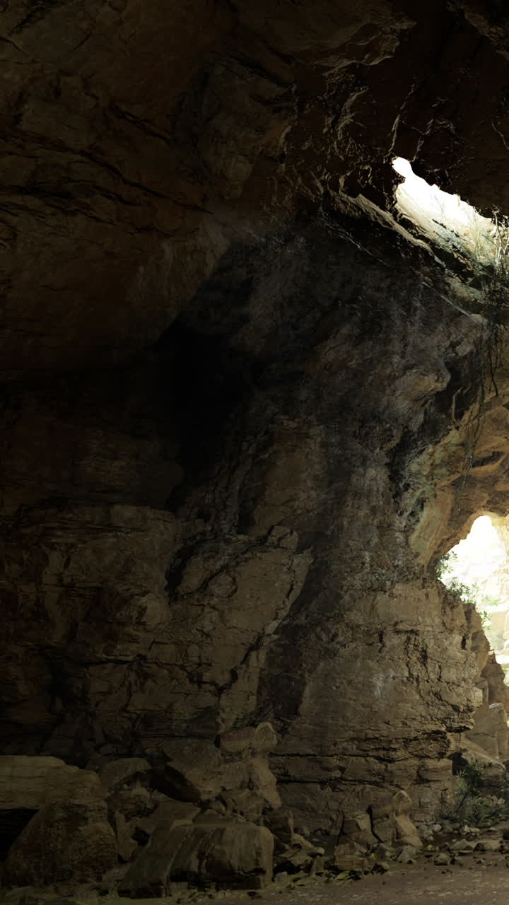 Grotta di pietra con luce che filtra in una località remota durante il giorno.