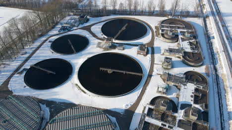 stunning aerial of water basins at sewage treatment plant in winter