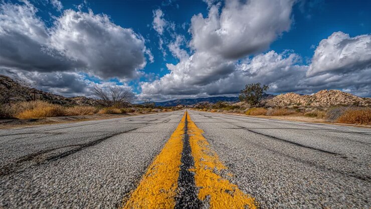 Una strada di campagna tranquilla sotto un cielo nuvoloso spettacolare: cattura l'essenza della solitudine e dell'avventura in un paesaggio remoto