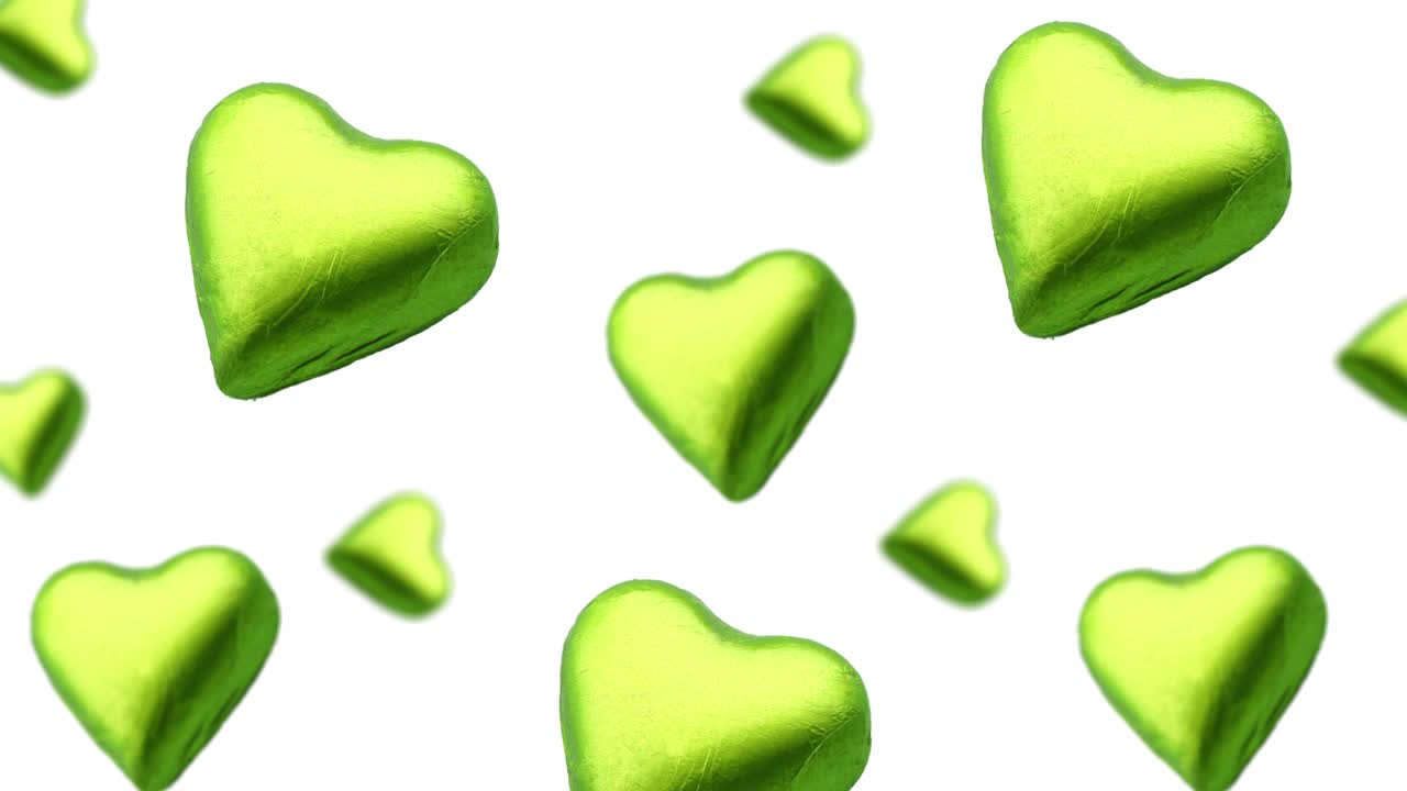 A stream of many different diameters heart shape wrapped colorfulchocolate candy flying on a white color background.Romantic template Love concept for mother's, St. Valentine's and women's Day