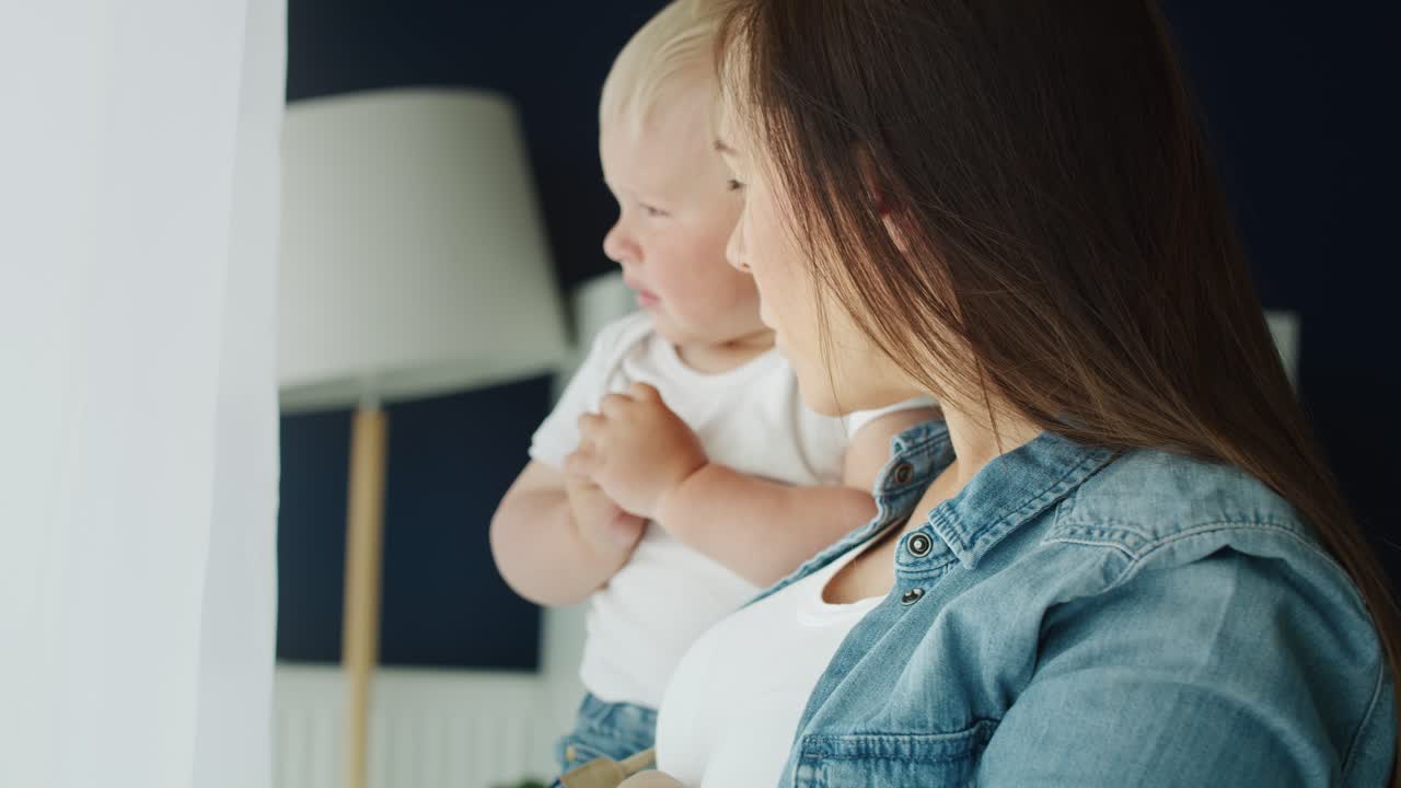 엄마 와 아기 가 창  ⁇  에 서 있는 동영상