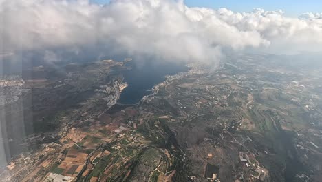 early morning flight in clouds view from the window of a passenger seat in an airplane on malta