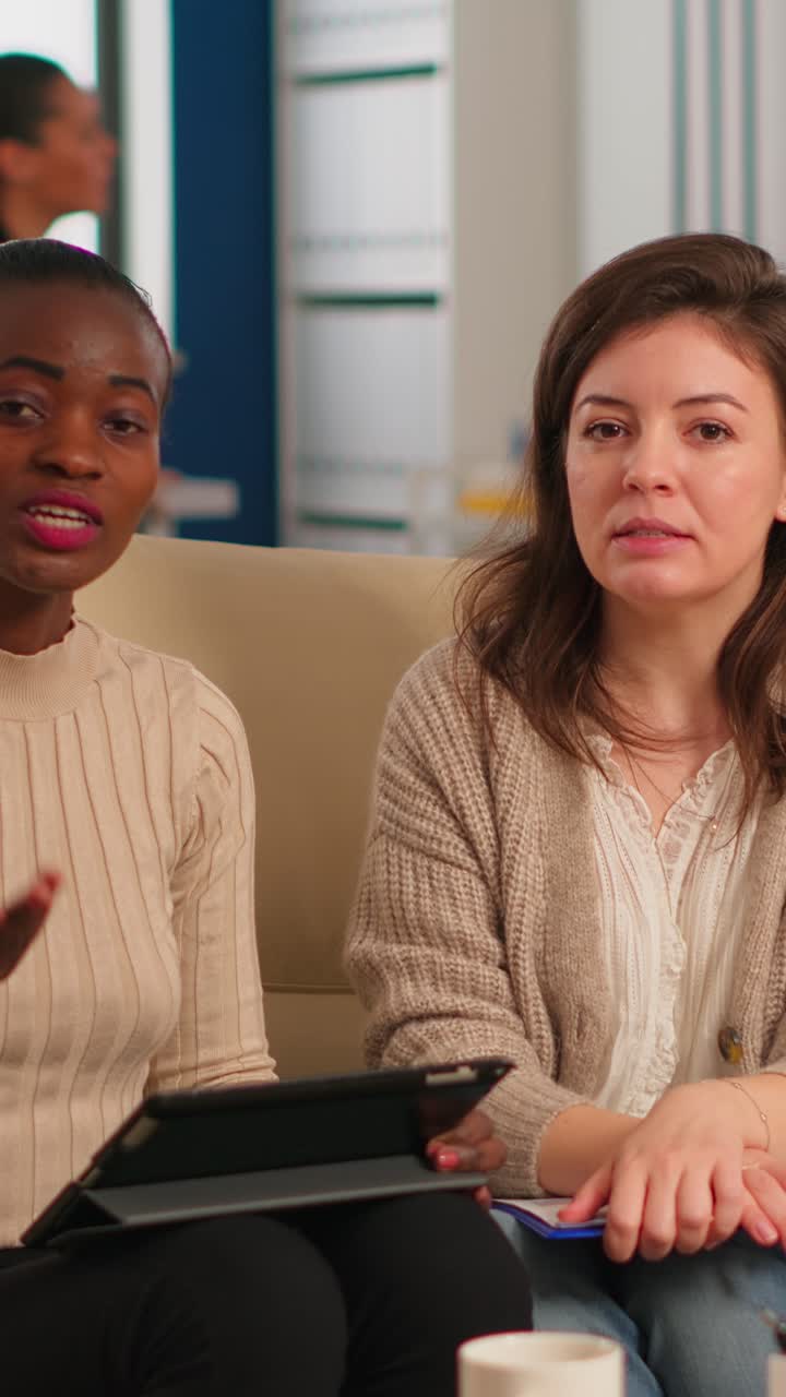Vertical video Team from start up company talking during video meeting sitting on couch