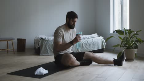 man resting after workout, drinking water