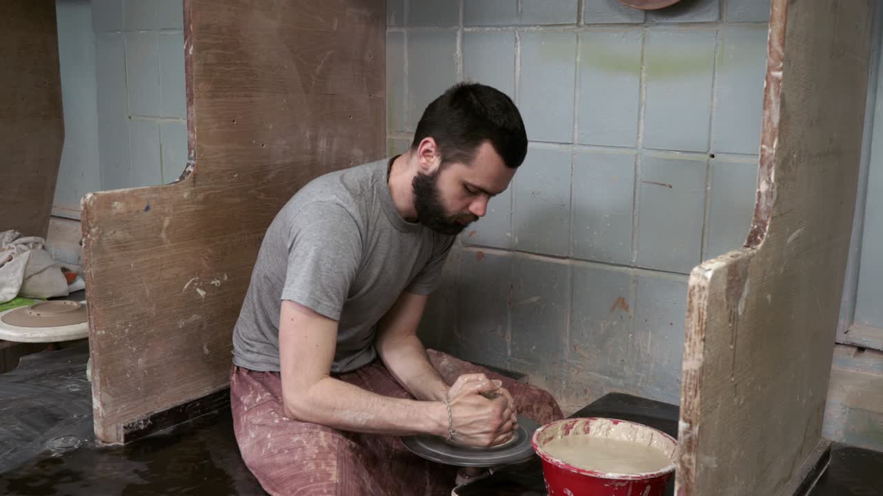 el alfarero hace una jarra de arcilla. ceramista. un hombre hace un jarrón en la rueda del alfarero