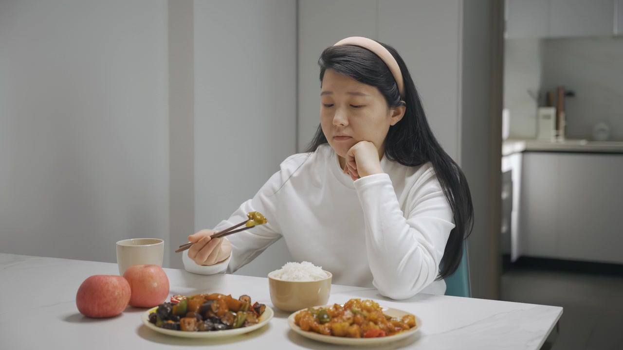キッチンテーブルに一人座り、健康的な食事や野菜の皿を嫌悪感とともに絶望的に見つめる、食欲不振、摂食障害、うつ病を抱える不幸で孤独な若い女性の肖像