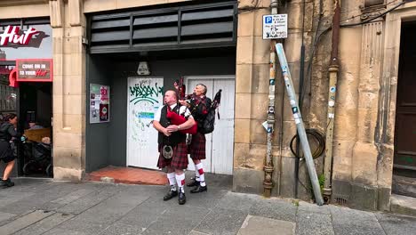 two performers playing bagpipes on edinburgh street