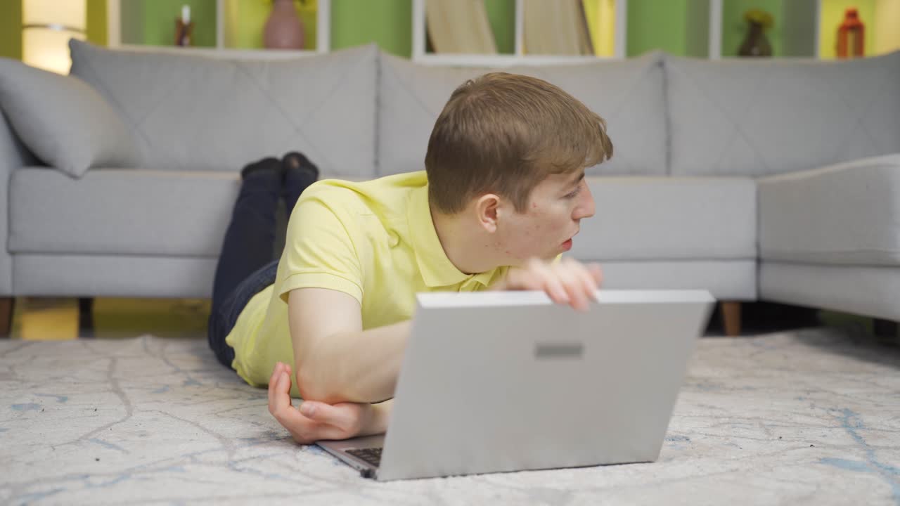 молодой человек смотрит фильмы ужасов на ноутбуке дома.