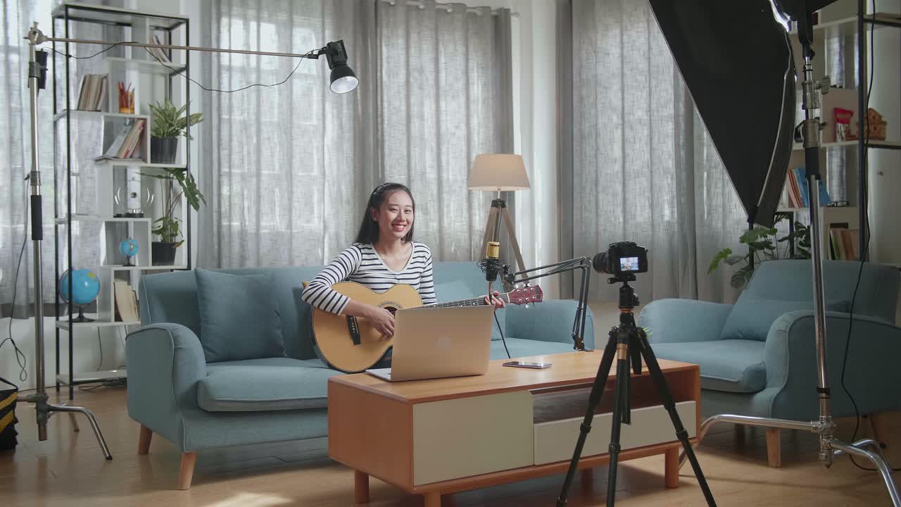 가정 스튜디오 에서 기타 를 연주 하는 여자