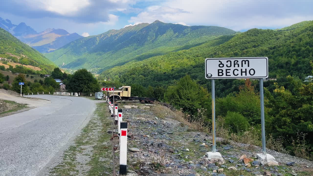 Scenic mountain landscape with a road and a sign