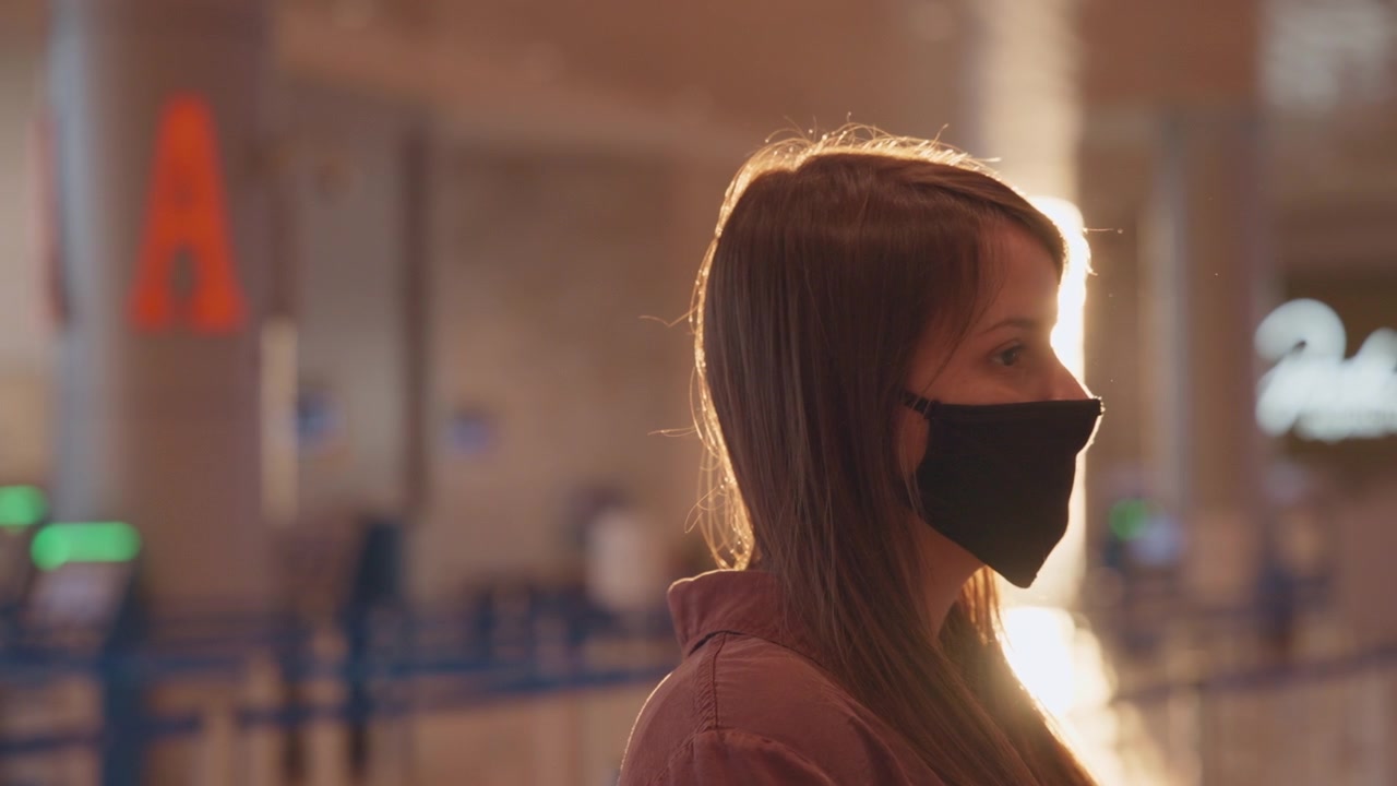 Woman in mask waiting at the airport