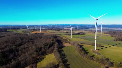 graceful wind turbines over green fields against a vibrant sky
