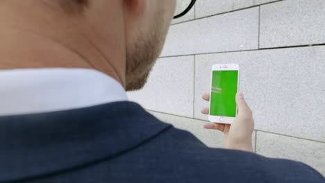 hombre de negocios que tiene una videochat en un teléfono inteligente en street.manager usando un teléfono móvil