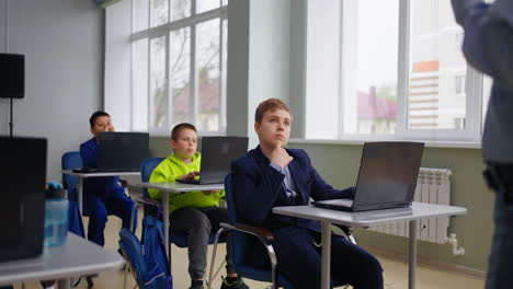 Students in a classroom listening to a teacher