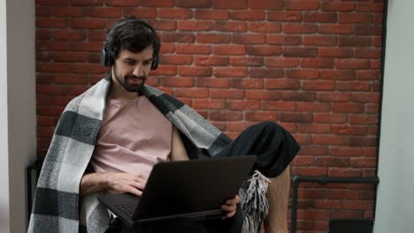 happy young man with laptop, listening music and relax at home