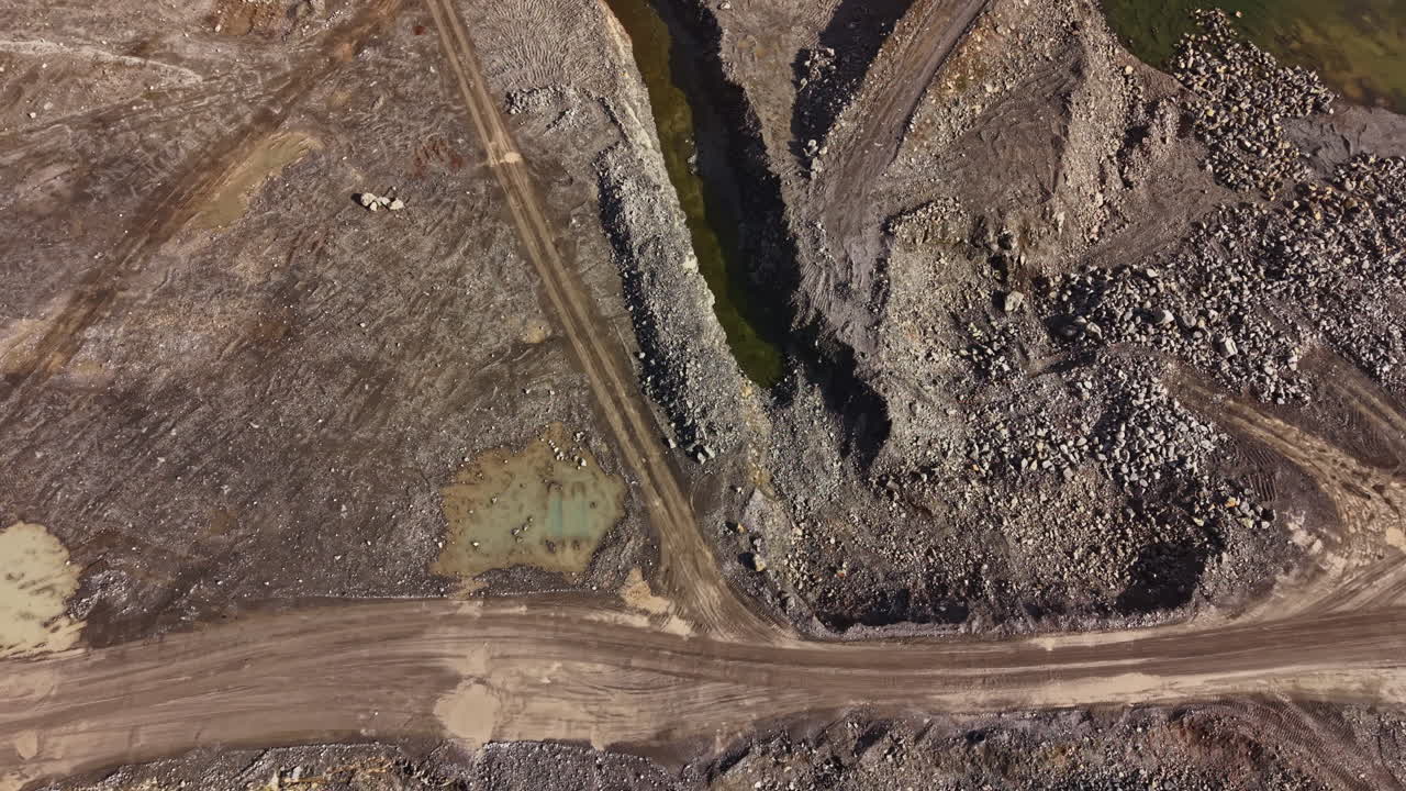 Granite quarry site with rock formations and dirt paths during daylight hours in a remote area