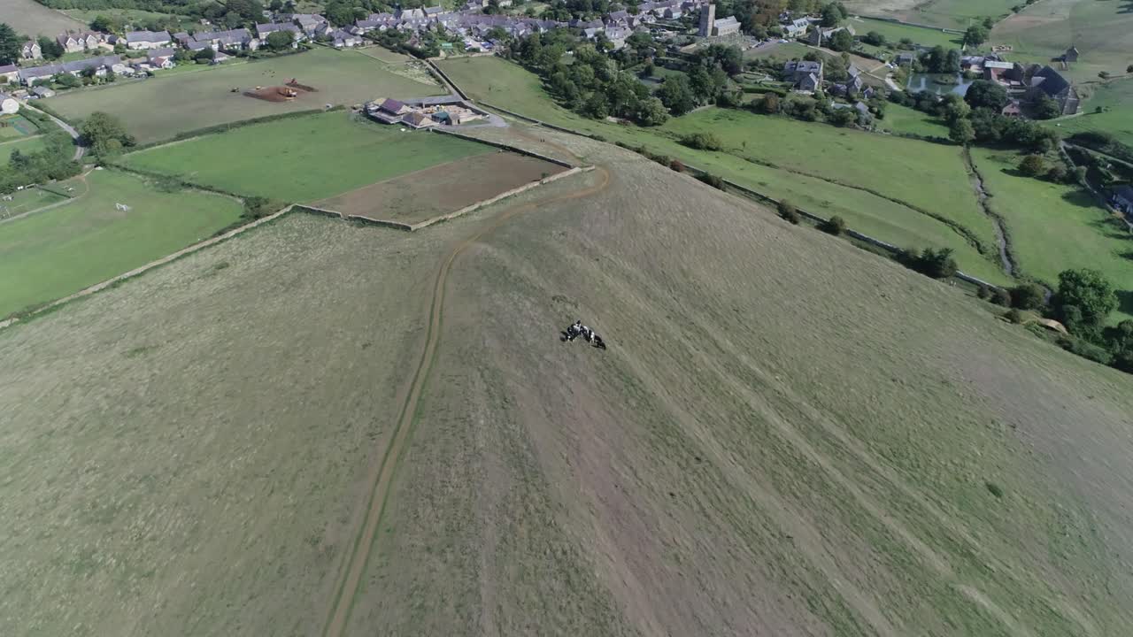Aerial view of a countryside landscape with a hill and village