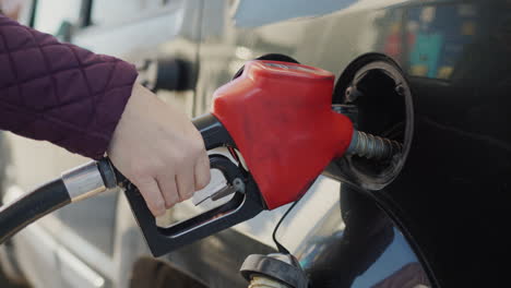 el conductor llena su coche con combustible líquido