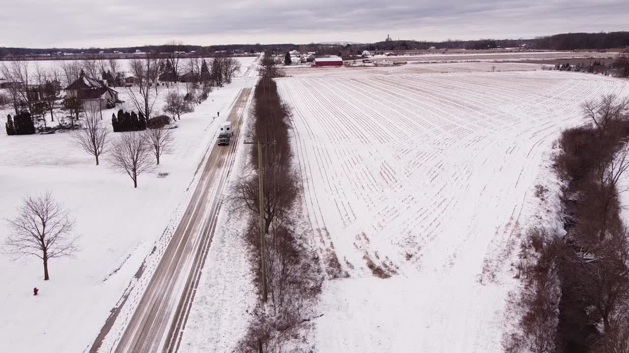 미시간의 얼어붙은 겨울 도로에서 말 트레일러를 운반하는 트럭을 픽업합니다.