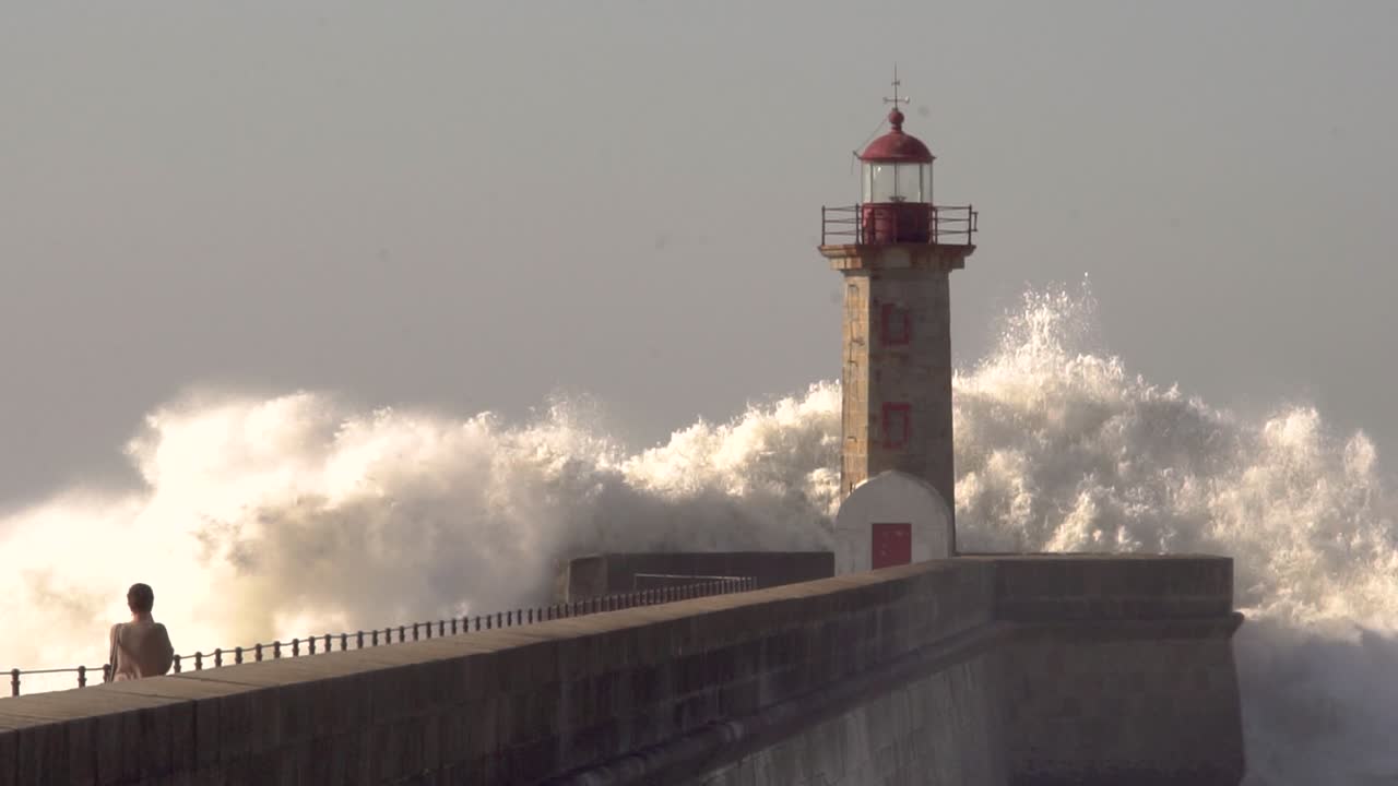 grandes olas rompen sobre el faro en la ciudad de oporto en portugal