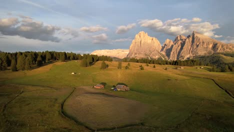 pequeñas cabañas cerca de enormes montañas rocosas en el campo