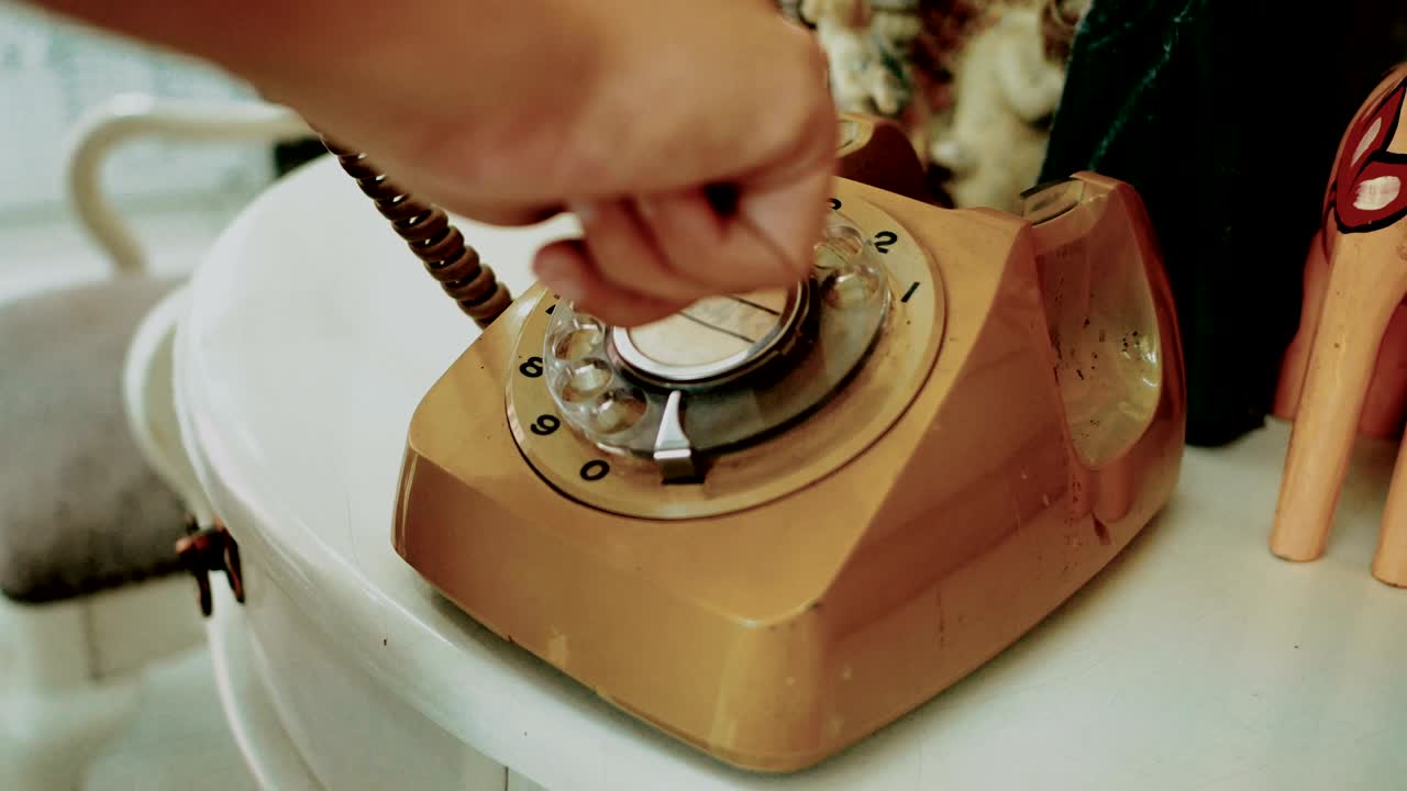 4K. people use finger dialing an retro rotary vintage style telephone. film dye for vintage tone. old telecommunication technology