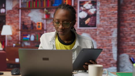 woman at home taking break from work to look at social media feed on tablet