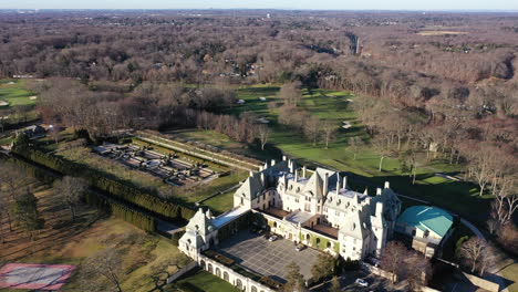 an aerial view over a large, upscale, luxury mansion with an eight reflection pool fountain, on long island, ny