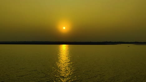 golden sun reflecting on calm river water at sunset