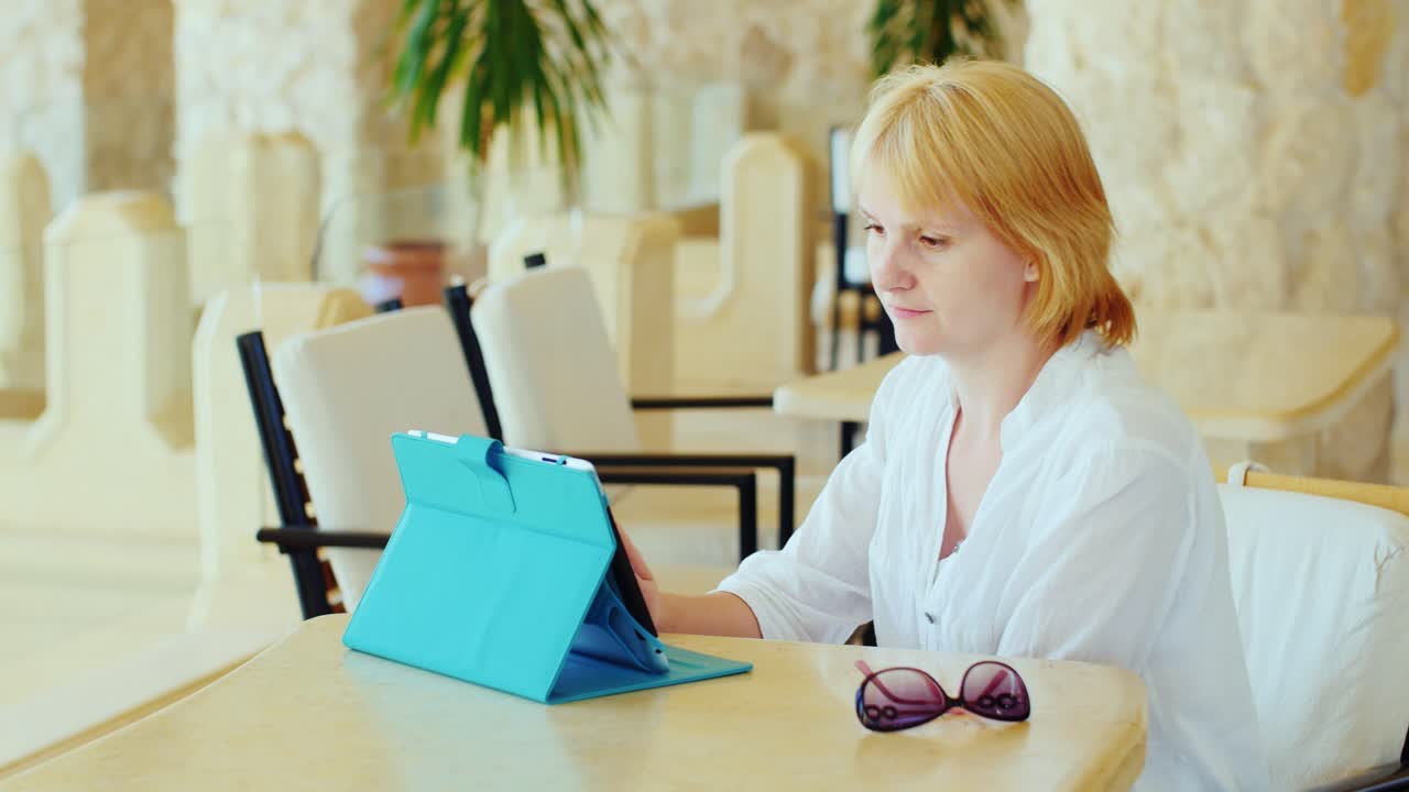 женщина-туристка наслаждается планшетом она отдыхает за столиками в кафе всегда онлайн интернет на va