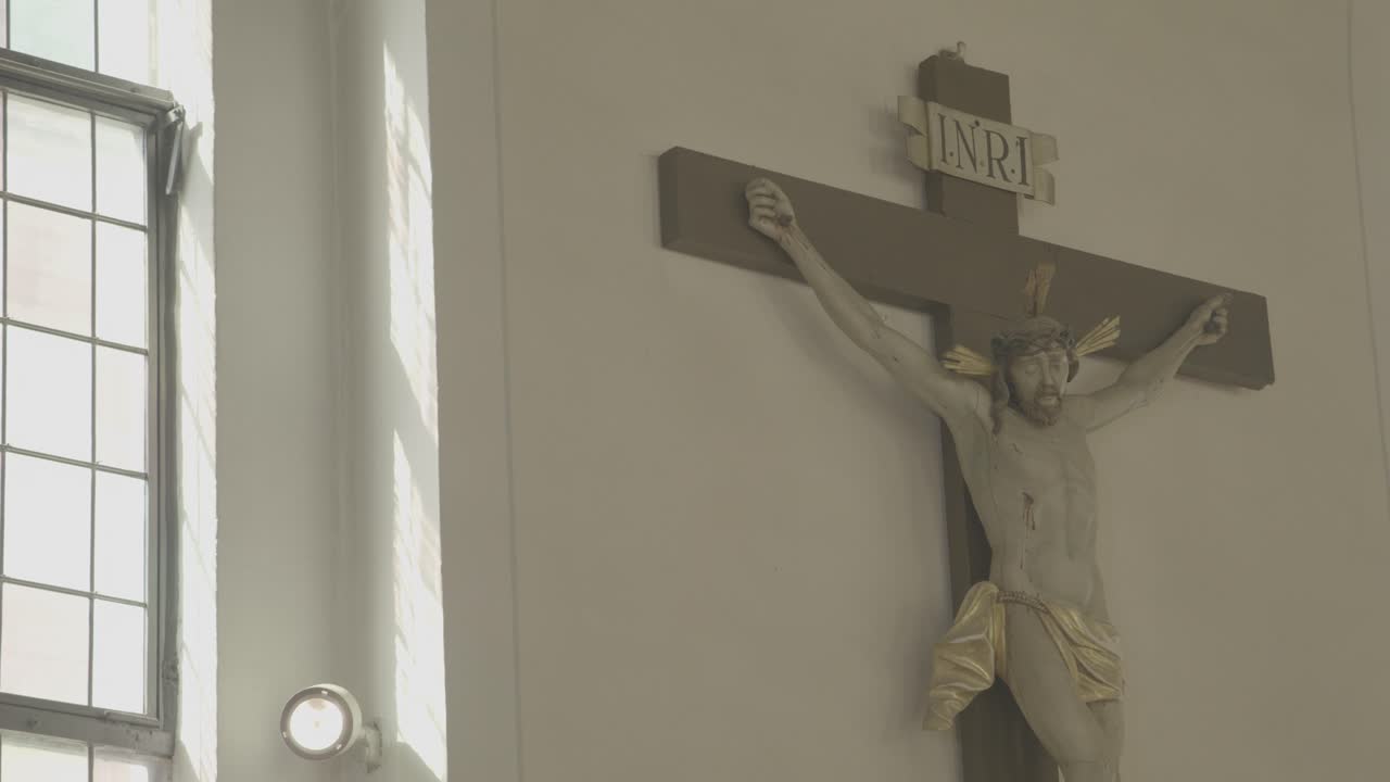 la cámara enfoca un crucifijo en una iglesia, un candelabro en primer plano