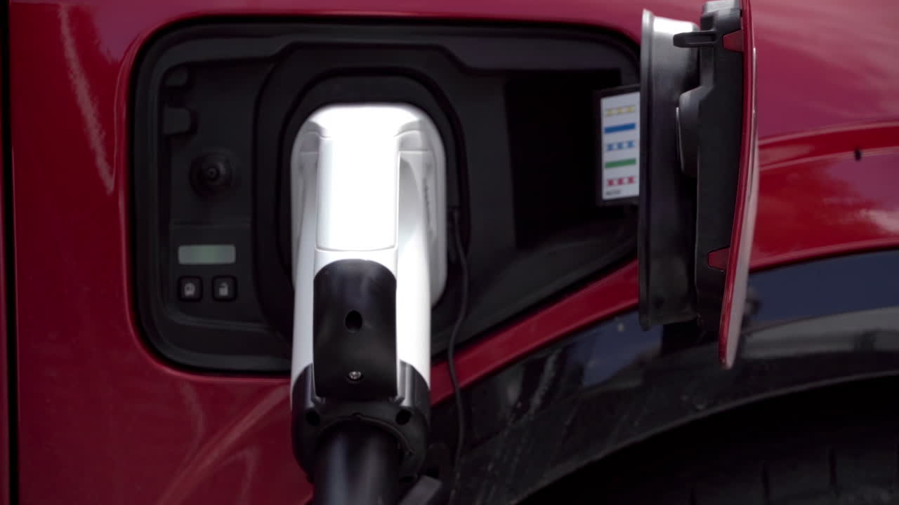 Close up of a red, electric car charging