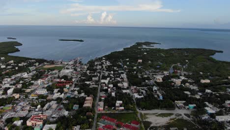 Aerial-view-moving-forward-shot,-scenic-view-of-houses-in-Baja-Sur,-Mexico,-Deep-blue-sea-and-sky-in-the-background