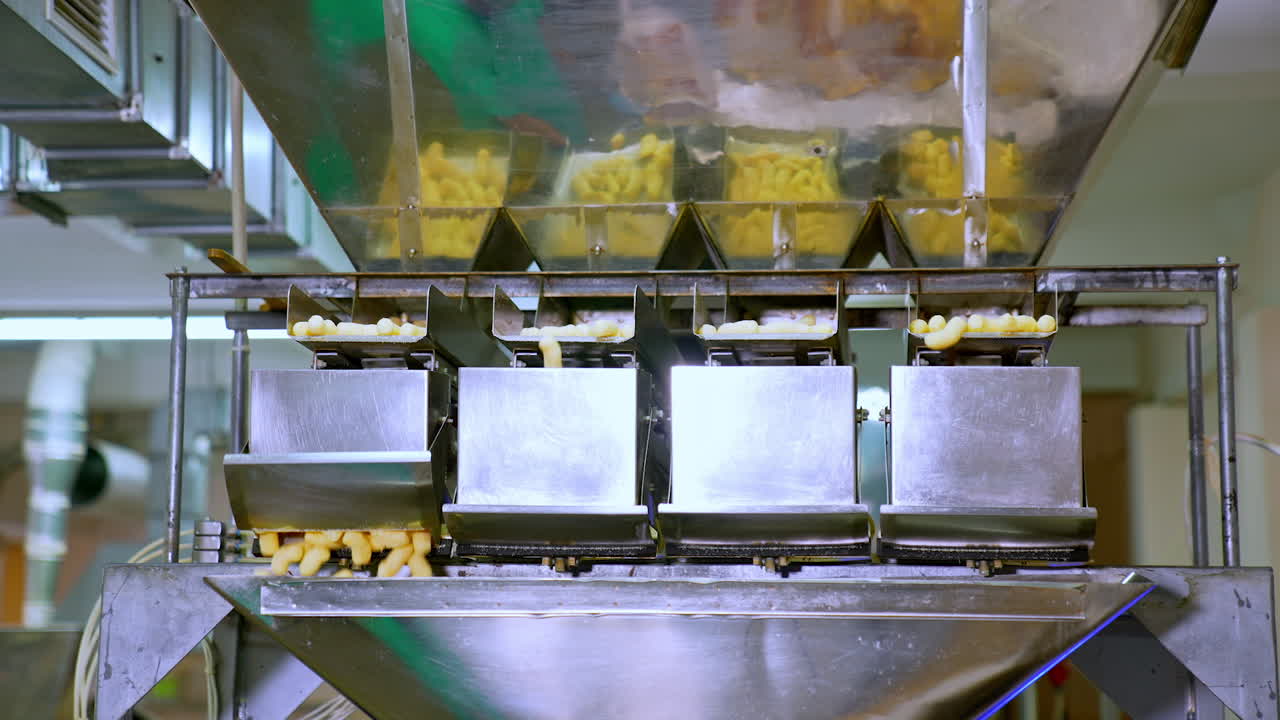 Industrial food products manufacturing at modern factory. Metal equipment for producing vegetarian maize snacks.