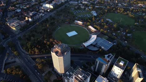 apartment blocks, parks, cricket ground, green space, aerial tilt down