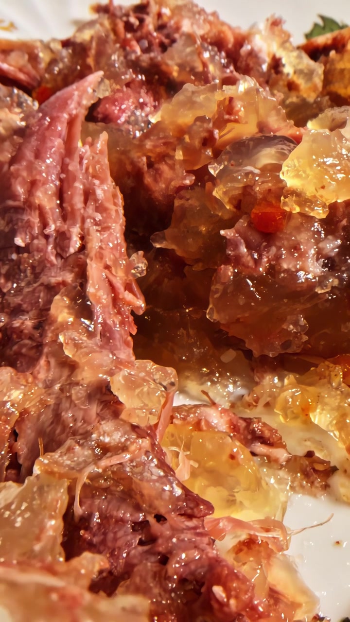 Aspic di carne tradizionale con maiale sfilacciato e gelatina naturale su piatto decorato vintage, holodets dell'Europa orientale in primo piano, video verticale con carrello.