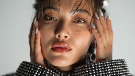 fashion model posing in slow motion, touching face and looking at camera