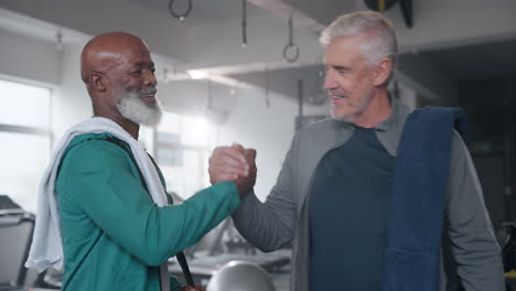 two senior men meeting at the gym