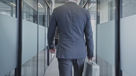 man in business suit walking empty office corridor, meeting with partners