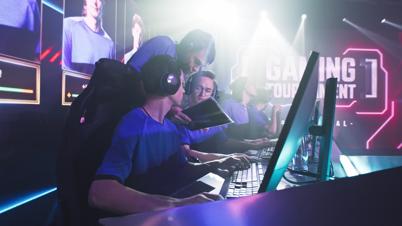young Cyber Sportsmen Discussing Strategy with Coach Trainer in Headset Explaining Strategy to Young Esports Gamers at Start of Professional Esports Championship