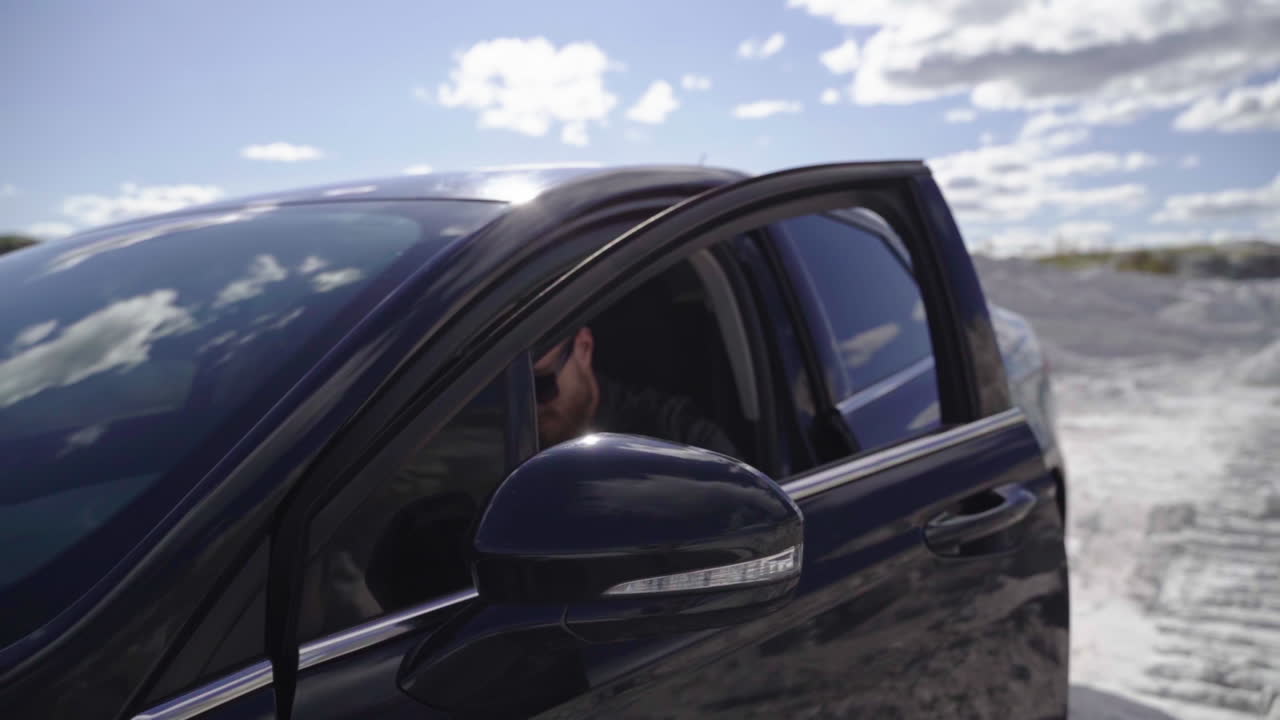 Handsome brutal man in car. Casual young man going out luxury car