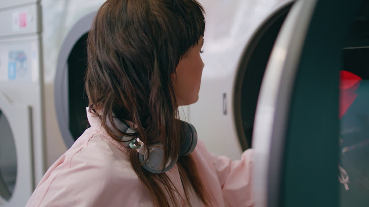 mujer tomando la ropa de color de primer plano del tambor. mujer confundida sosteniendo calcetín rojo