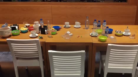 general view of the table and chairs in a bar with bottles cups and clutter after customers leave, shooting turning right, orders, galicia, spain