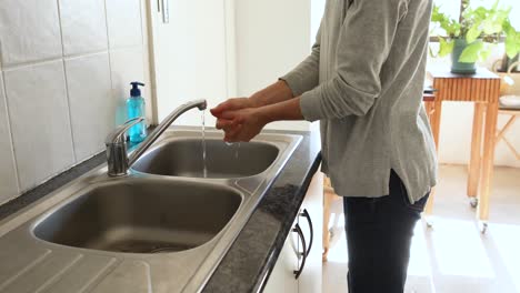 Caucasian-woman-washing-her-hands-with-soap-at-home